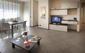 a living room with a table and a tv in it at Residence Calissano in Alba