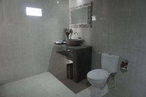 ウルワツにあるNyang - Nyang Bungalow Uluwatuのトイレ、洗面台、鏡のあるバスルーム