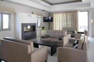 a living room with couches and a fireplace and a tv at Achilles Hotel in Methoni