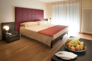 um quarto com uma cama e uma tigela de fruta numa mesa em Residence Calissano em Alba