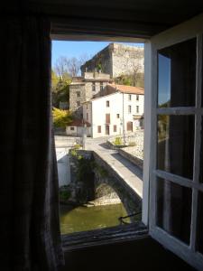 een raam met uitzicht op een brug over een rivier bij Chateau View Chambres d'hôtes in Quillan