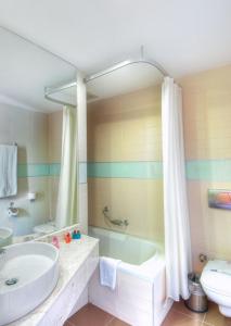 a bathroom with a tub and a sink and a toilet at Golden Lotus Hotel in Kemer