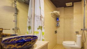 a bathroom with a blue bowl sink and a toilet at Floral Hotel · Spring Guesthouse Zhangjiajie in Zhangjiajie +146 photos