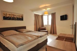 a bedroom with a bed and a chair in it at Lagadin Lakeview Apartment in Ohrid