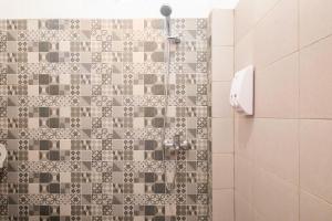 a bathroom with a shower with a tile wall at RedDoorz near Exit Toll Moh. Toha in Bandung