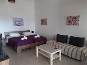 a room with two beds and a couch and a tv at ZORBAS Sea View No 5 in Larnaca