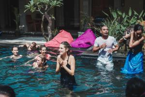 eine Gruppe von Menschen in einem Becken mit Wasser in der Unterkunft Dedeane ubud in Ubud