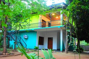 een huis met een balkon en een trap bij Kuma Safari Lodge in Udawalawe