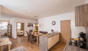 kuchnia i salon ze stołem i krzesłami w obiekcie Appartement Living Schönwies including Zell am See-Kaprun summercard w mieście Zell am See
