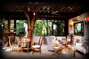 a living room with chairs and a table and a tree at Hotel La Semilla a Member of Design Hotels in Playa del Carmen