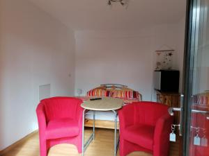 ein Esszimmer mit rosa Stühlen und einem Tisch in der Unterkunft Pension und Bistro" Dat olle Fischerhus" in Ralswiek