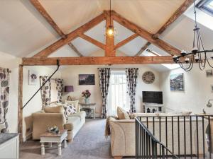 a living room with wooden ceilings and beams at The Coach House in Matlock
