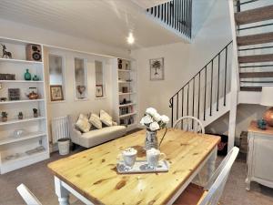 a living room with a wooden table and a staircase at The Coach House in Matlock