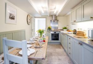 a kitchen with a wooden table with plates on it at East Row Lodge in Whitby