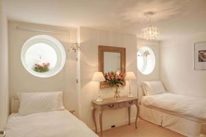 a bedroom with two beds and a table with a mirror at East Row Lodge in Whitby