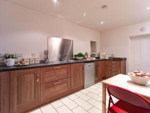 a kitchen with wooden cabinets and a bowl of fruit on a table at Quayside in Whitby +7 photos