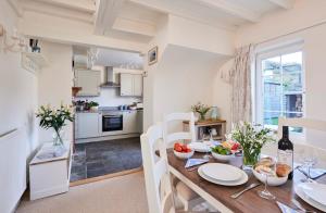 a kitchen and dining room with a wooden table and a dining room at Rigg Cottage in Whitby