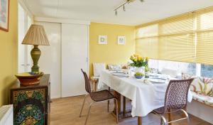 Seacliff Cottage في ويتبي: غرفة طعام مع طاولة مع الزهور عليها