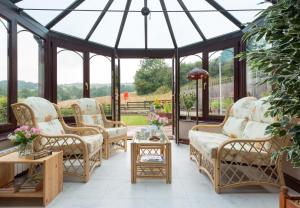 a conservatory with chairs and tables and a glass roof at Seawinds in Whitby