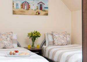 a room with two beds and a table with a tray of food at Sunny Corner Cottage in Filey
