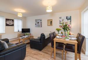 a living room with a couch and a table at Sunny Corner Cottage in Filey