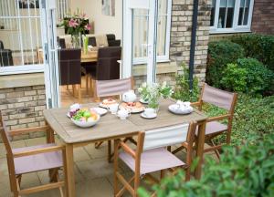 a wooden table with bowls of fruit on a patio at Sunny Corner Cottage in Filey +6 photos