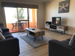 a living room with a couch and a tv at Murchison View Apartments in Kalbarri