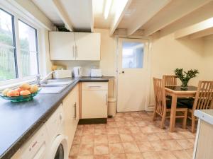 eine Küche mit Spüle und einer Obstschale auf der Arbeitsplatte in der Unterkunft 4 Rose Cottages in Looe