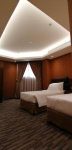a hotel room with two beds and a window at Manazel Al Diafa Serviced Apartments in Riyadh