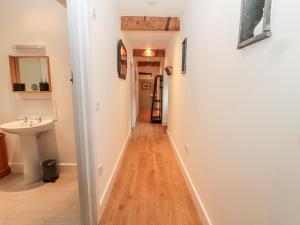 einen Flur, der zu einem Bad mit einem Waschbecken führt in der Unterkunft The Old Workshop in Belford + 35 Fotos