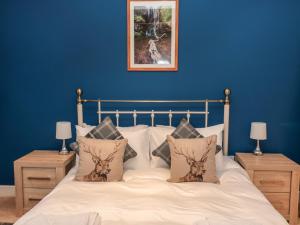 ein Schlafzimmer mit einem Bett mit einer blauen Wand in der Unterkunft The Old Workshop in Belford