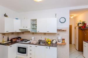 a kitchen with white cabinets and a sink at Apartments Captain in Dubrovnik