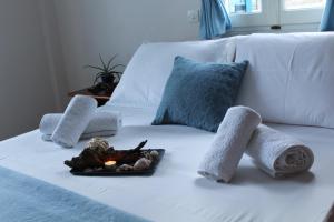 a bed with towels and a plate of food on it at Armenaki Apartments in Sampatiki