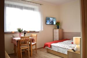 a bedroom with a table and a bed and a window at Willa Bea in Gdańsk