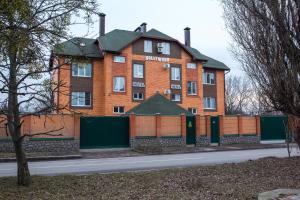 a large brick building with a fence in front of it at HOLLYWOOD in Poltava