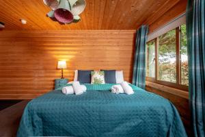 a bedroom with a bed with a blue comforter at Redlands Country Lodge Apartments with Hot Tubs in Ladybank