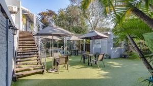 a patio with tables and chairs and umbrellas at Silver Oaks Boutique Hotel in Durban