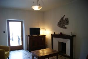 Una sala de estar con chimenea y televisión. en La piscine de tonton Jean, en Caunes-Minervois