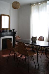 une salle à manger avec une table, des chaises et une cheminée dans l'établissement La piscine de tonton Jean, à Caunes-Minervois