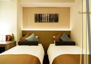 two beds sitting next to each other in a room at Nippombashi Crystal Hotel Ⅱ in Osaka