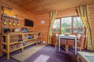 a dining room with a table and chairs in a cabin at Redlands Country Lodge Apartments with Hot Tubs in Ladybank