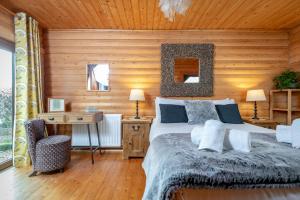 a bedroom with a bed and a wooden wall at Redlands Country Lodge Apartments with Hot Tubs in Ladybank