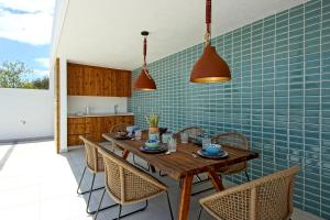 uma cozinha com uma mesa de madeira e cadeiras em Villa Ocean Marina, Panoramic and heatable Pool em Albufeira