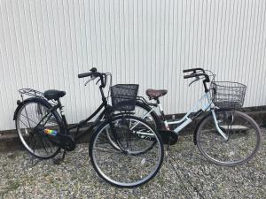 duas bicicletas estão estacionadas ao lado de uma parede em 蒼 aoi em Shingu