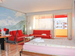 ロカルノにあるApartment Residenza Lido-24 by Interhomeの赤い家具と絵画が飾られたリビングルーム