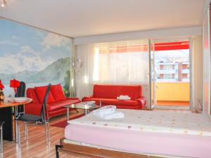 ein Wohnzimmer mit roten Möbeln und einem Gemälde in der Unterkunft Apartment Residenza Lido-24 by Interhome in Locarno