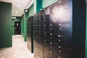 a row of lockers in a room with green walls at Wink at Mosque Street in Singapore
