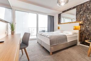 a hotel room with a bed and a desk and a desk at Apartamenty Almar Seaside Park Private in Kołobrzeg +81 photos