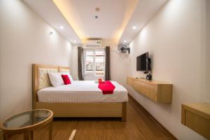 a small bedroom with a bed and a tv at RedDoorz Newstyle Apartment Tran Duy Hung in Hanoi