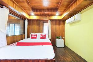 a bedroom with a large bed with red pillows at OYO 604 Ruen Mai Horm Resort in Trang